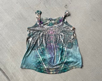 May include: A sleeveless tank top with a colorful floral and paisley print. The top is made of a soft, lightweight fabric and has a relaxed fit.