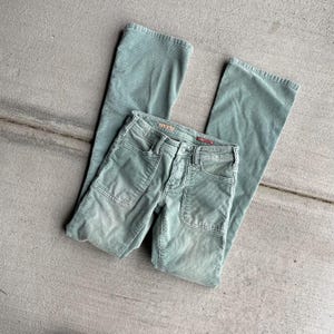 May include: A pair of green corduroy pants with a wide leg and a front pocket detail. The pants are made of a soft, comfortable fabric and have a relaxed fit.