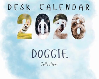 May include: A desk calendar with the text "DESK CALENDAR 2026 DOGGIE Collection". The numbers of the year are filled with images of different dog breeds, including a Corgi, a Border Collie, a Golden Retriever, and a Goldendoodle. The background is a light blue watercolor wash.