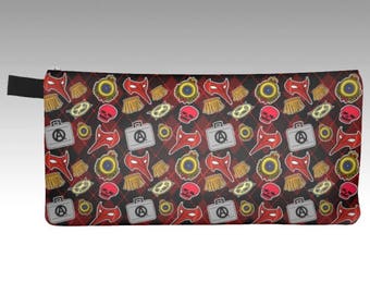 May include: A red and black zippered pencil case with a repeating pattern of skulls, masks, and other symbols.