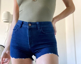 May include: A pair of dark blue denim shorts with a frayed hem. The shorts have a high waist and a classic five-pocket design.