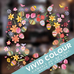 Könnte beinhalten: Ein bunter Osterkranz mit Blumen und Eiern. Der Kranz besteht aus verschiedenen Blumen, darunter rosa, gelbe und orangefarbene. Die Eier sind mit Streifen, Punkten und anderen Mustern verziert. Der Kranz ist von einem blauen Banner mit dem Text "VIVID COLOUR VIEWABLE DAY OR NIGHT, INSIDE OR OUTSIDE" umgeben.
