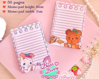 May include: Two pink memo pads with lined paper and cute cartoon bears and bunnies. The memo pads are 7 cm wide and 10 cm tall and have 50 pages each. The memo pads are part of a set called "Bear Bunny Diner" by Spiruts.