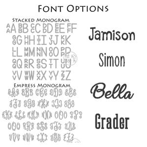 May include: A chart titled FONT OPTIONS displaying two monogram styles labeled STACKED MONOGRAM and EMPRESS MONOGRAM, each featuring letters A through Z. To the right, four names are embroidered in black: Jamison, Simon, Bella, and Grader.