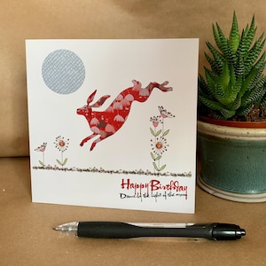 Leuke verjaardagswenskaart met haas - bedrukte handgetekende kaart voor vrienden met slogan 'Happy Birthday Dance by the light of the moon'