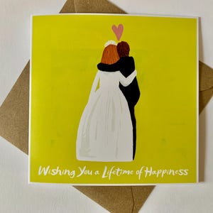 Tarjeta de boda con una pareja vestida de novia y el lema 'Les deseo una vida llena de felicidad'