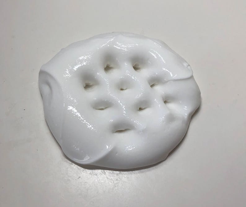 May include: White slime with a grid pattern of holes pressed into it.