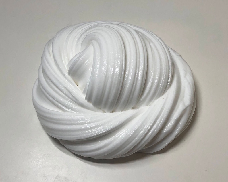 May include: White slime with a smooth, glossy texture. The slime is folded and twisted into a swirl pattern.
