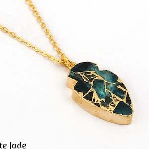 May include: A gold-colored necklace with a pendant featuring a teal-colored, mosaic-style stone. The pendant is shaped like an arrowhead. The text "9. Apatite Jade" is at the bottom of the image.