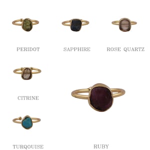 May include: Set of 6 gold rings with different colored gemstones. The gemstones are peridot, sapphire, rose quartz, citrine, turquoise, and ruby.