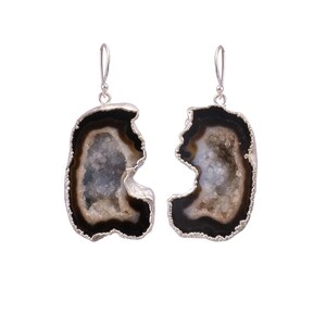 May include: A pair of silver earrings with black and white agate stone accents. The agate is a natural stone with a unique pattern and texture.