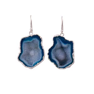 Puede incluir: Un par de pendientes de plata con gotas de piedra de ágata azul. El ágata es una piedra natural con una formación cristalina.