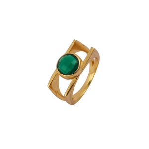 Puede incluir: Un anillo de oro con una piedra preciosa verde engastada en un diseño geométrico.