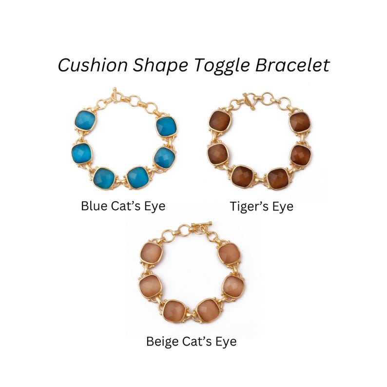 Op de afbeelding: Drie gouden toggle-armbanden met kussenvormige stenen. De armbanden worden op een witte achtergrond getoond. De stenen zijn blauw, bruin en beige. De tekst "Cushion Shape Toggle Bracelet" staat bovenaan de afbeelding. De tekst "Blue Cat's Eye", "Tiger's Eye" en "Beige Cat's Eye" staat onder de armbanden.