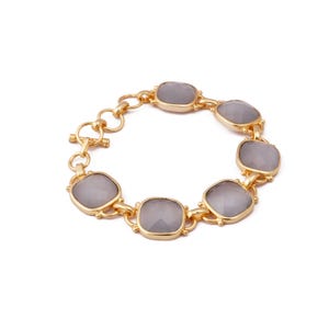 May include: A gold chain bracelet with six gray faceted stones. The bracelet has a toggle clasp.