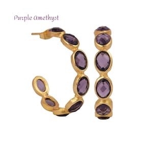 May include: A pair of gold hoop earrings with purple amethyst stones. The earrings are made of gold and have a polished finish.