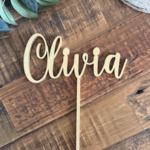May include: A handmade wooden sign with the text "Welcome" in a handwritten style. The sign is painted white with a distressed finish and features a small, decorative heart. It is designed for indoor or outdoor use.