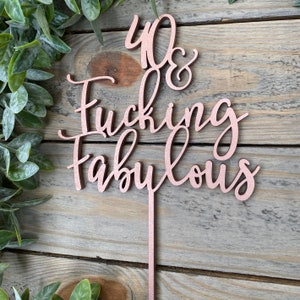 May include: Rose gold cake topper with the text "40 & Fucking Fabulous".