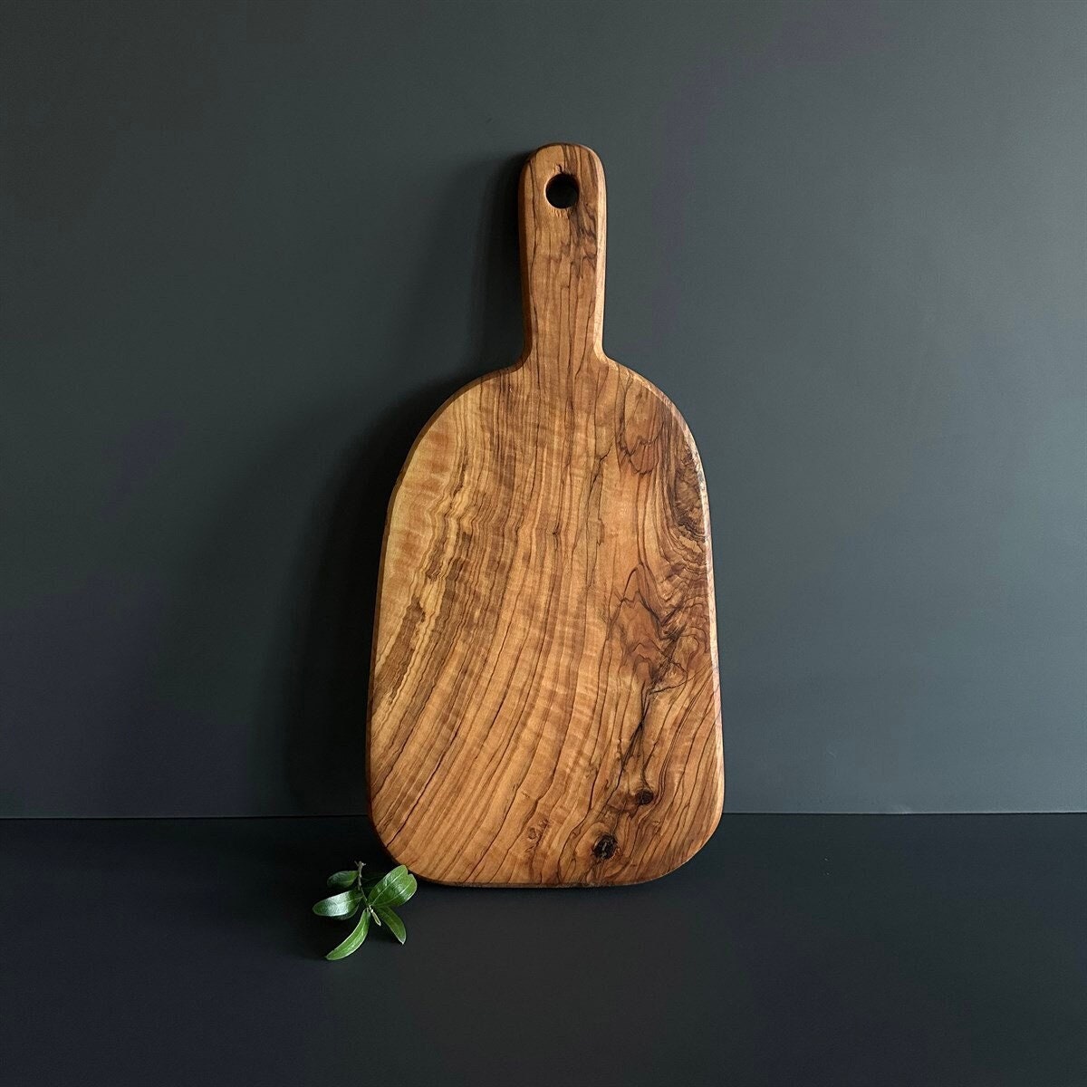 planche à découper en bois d'olivier fabriquée la main, indispensable pour une cuisine rustique et durable.