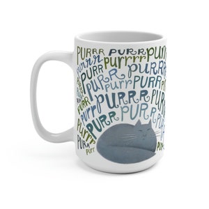 May include: White ceramic mug with a blue and green design of the word "purr" repeated many times. A gray cat is sleeping in the center of the design.