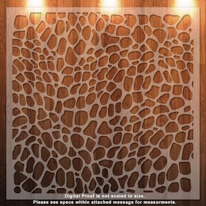 Könnte beinhalten: Eine weiße Schablone mit einem Muster aus unregelmäßigen Kreisen, die an die Haut einer Giraffe erinnern. Die Schablone liegt auf einer braunen Holzoberfläche.