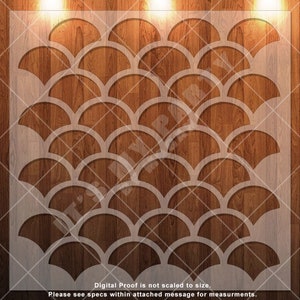 May include: A white stencil with a repeating pattern of overlapping half-circles, resembling fish scales, on a woodgrain background.