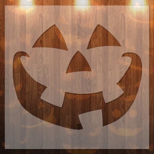 May include: A white stencil of a jack-o'-lantern face on a woodgrain background. The stencil is cut out in the shape of a traditional jack-o'-lantern face with a wide smile, two eyes, and a triangular nose.