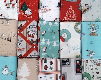 May include: A collection of fifteen folded fabric squares featuring Peanuts characters in various holiday scenes. The patterns include Snoopy, Charlie Brown, and Woodstock with Christmas trees, wreaths, snowmen, gifts, and text like Warm & Cozy.