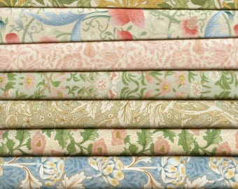 Pode incluir: Uma pilha de tecido com padrões florais em tons de verde, rosa, azul e amarelo. O tecido está dobrado cuidadosamente e os padrões são visíveis em cada camada.
