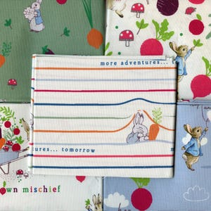 May include: A collection of fabric squares featuring a Peter Rabbit theme. The fabrics are in various colours and patterns, including green, blue, white, and red. The fabrics feature images of Peter Rabbit, vegetables, and text that says "more adventures..." and "own mischief".