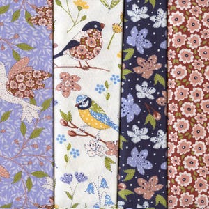 May include: Four fabric swatches with floral and bird designs. The fabrics display lavender, white, navy, and maroon hues. The patterns include birds, flowers, and leaves, with a stitched embroidery style. The swatches are arranged side by side.