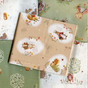 Puede incluir: Un conjunto de cuatro cuadrados de tela con un tema caprichoso de Peter Rabbit. Los cuadrados son en tonos de verde, blanco y beige con ilustraciones de Peter Rabbit, una ardilla, una rana y un cerdo.
