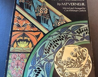 Może przedstawiać: Książka zatytułowana "FLORAL PATTERNS" ze 120 pełnokolorowymi wzorami w stylu Art Nouveau. Okładka zawiera kolorowe ilustracje kwiatowe w odcieniach pomarańczu, błękitu, zieleni i różu na czarnym tle. Autorem jest M.P. VERNEUIL.