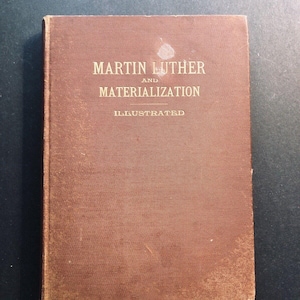 May include: A brown book with the title "Martin Luther and Materialization" in gold lettering. The book is illustrated.