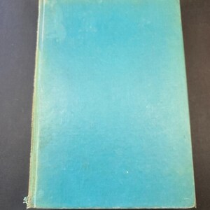 May include: A vintage book with a teal cover. The cover has a slightly textured appearance and shows signs of wear along the edges. The book is rectangular and appears to be closed, with the spine visible on the left side.