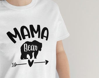 May include: White t-shirt with black text that reads "Mama Bear" and a black silhouette of a bear with an arrow and heart graphic.