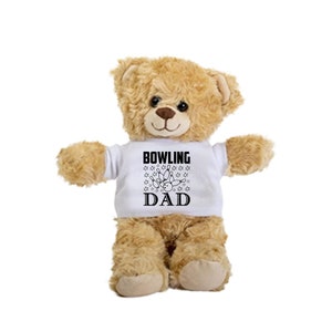 May include: A brown teddy bear wearing a white t-shirt with the text "BOWLING DAD" and a graphic of bowling pins and a bowling ball.