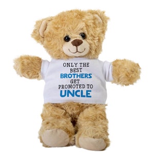 Puede incluir: Un oso de peluche marrón que lleva una camiseta blanca con el texto "Only the best brothers get promoted to uncle" en letras azules.