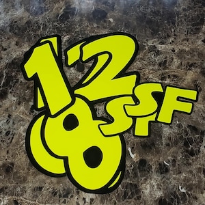 May include: Yellow numbers 1, 2, 8, and the letters S, F, in a bold black outline, on a dark brown background.