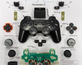 Decoración de pared desmontada con mando de PS2 negro enmarcado. Expositor desmontable en marco empotrado. Impresión personalizada de PS2 en papel satinado HD.