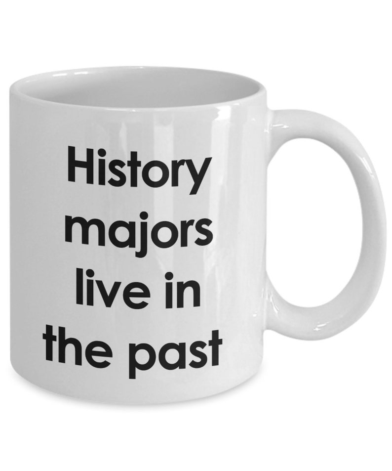 May include: White ceramic coffee mug with black text that reads "History majors live in the past".