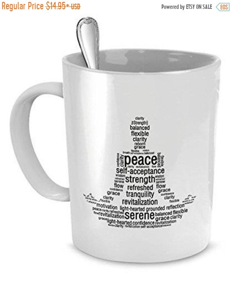 Op de afbeelding: Witte keramische koffiemok met een zwart-witte woordwolkontwerp in de vorm van een yogapose. De woorden omvatten "vrede", "zelfacceptatie", "kracht", "rust", "sereniteit" en "revitalisering".