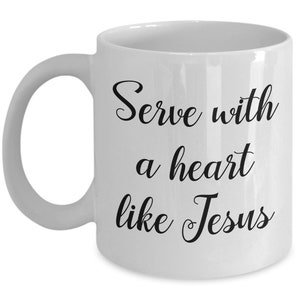 May include: White ceramic coffee mug with black text that reads "Serve with a heart like Jesus".