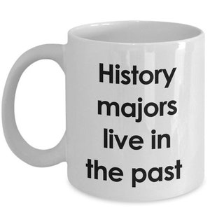 May include: White ceramic coffee mug with black text that reads "History majors live in the past".