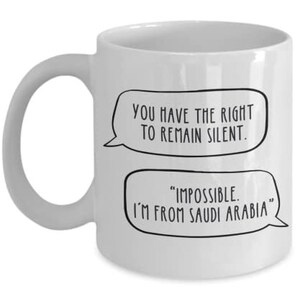 May include: White ceramic coffee mug with a black and white graphic of two speech bubbles. The top speech bubble says "You have the right to remain silent." The bottom speech bubble says "Impossible. I'm from Saudi Arabia."