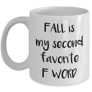 Peut inclure: Une tasse à café en céramique blanche avec du texte noir qui dit "FALL is my second favorite F WORD".