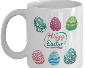 May include: White ceramic coffee mug featuring a colourful Easter egg design and the text "Happy Easter" in pink and red lettering.