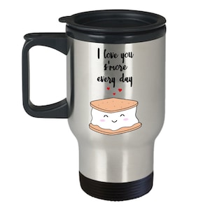 Może przedstawiać: Termos podróżny ze stali nierdzewnej z czarną pokrywką i uchwytem. Termos ma białą grafikę s'more z nadrukowanym tekstem "I love you s'more every day".