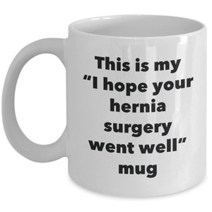May include: White ceramic mug with black text that reads "This is my "I hope your hernia surgery went well" mug"