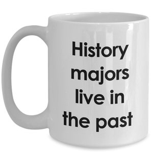 May include: White ceramic coffee mug with black text that reads "History majors live in the past".
